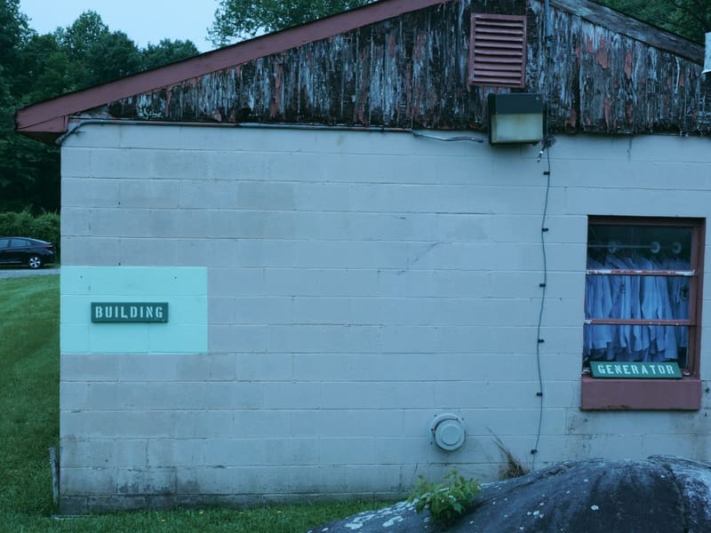 Weathered cinderblock generator building with stenciled BUILDING and GENERATOR signage