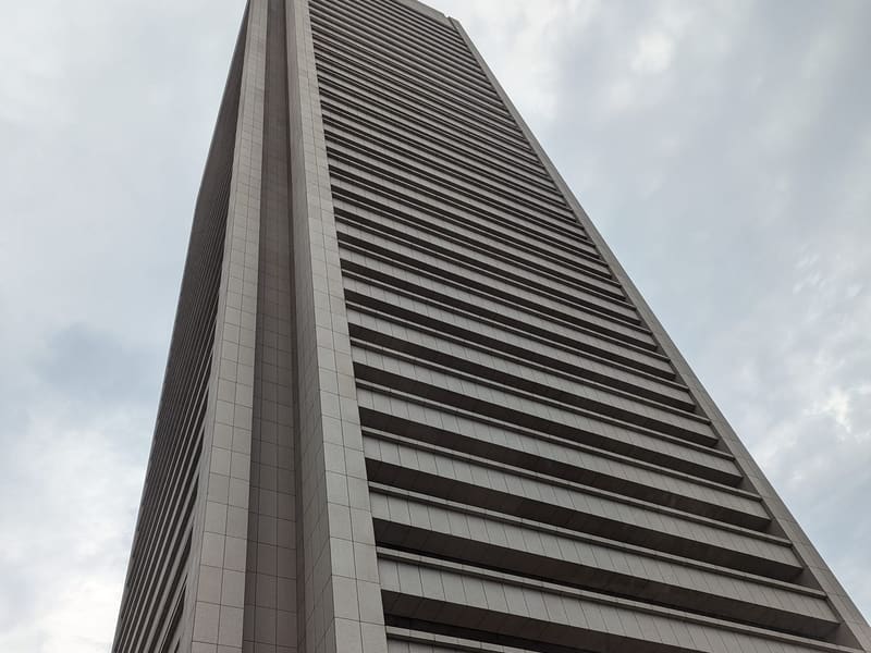 A tall modernist office tower seen from street level
