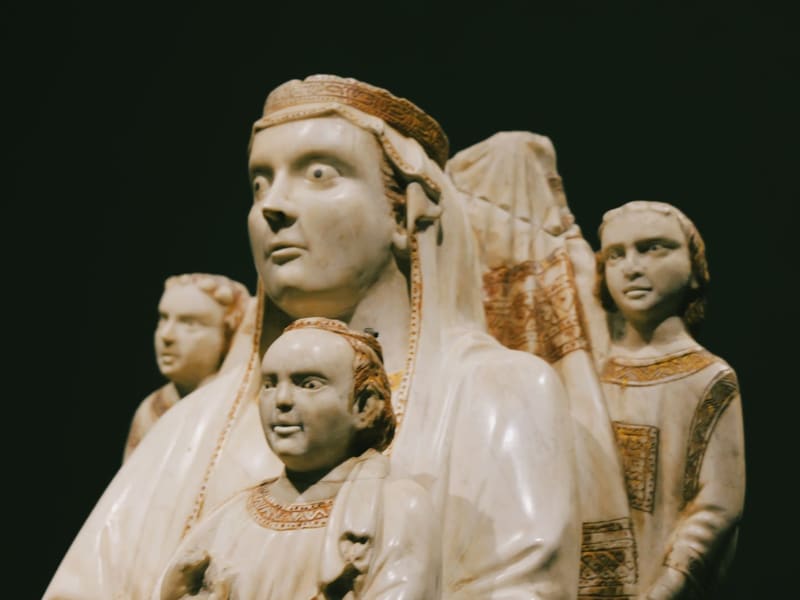 A medieval alabaster sculpture of robed figures, faces close up