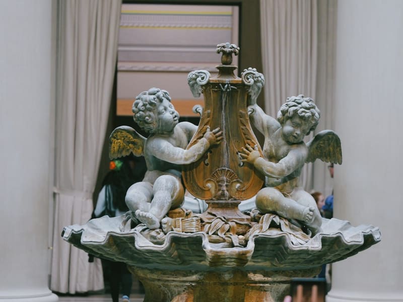 A marble fountain with two cherubs flanking an urn at the National Gallery