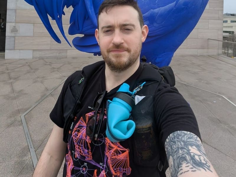Brian Thackston in front of the giant blue rooster sculpture at the National Gallery