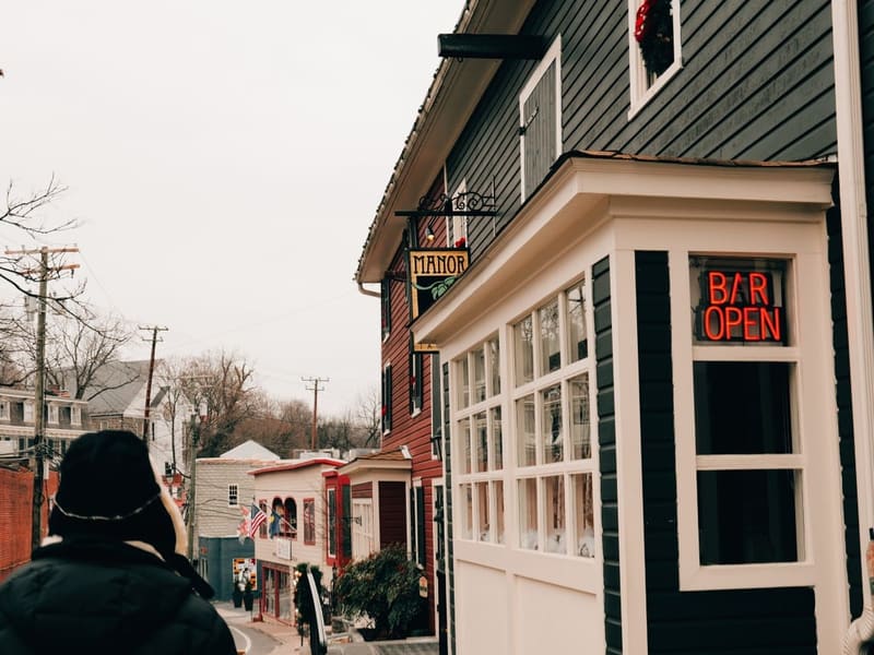 Main Street in Old Ellicott City, a 'Bar Open' neon glowing in a shopfront window