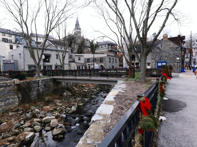 Old Ellicott City rooftops above the Tiber River, a steeple on the hill beyond