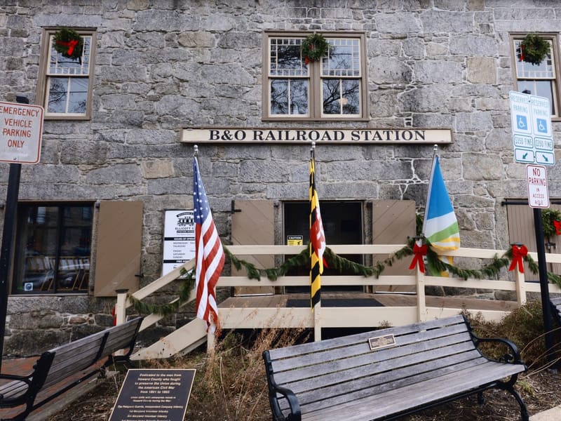 Stone facade of the B&O Railroad Station, decked with holiday garland and flags