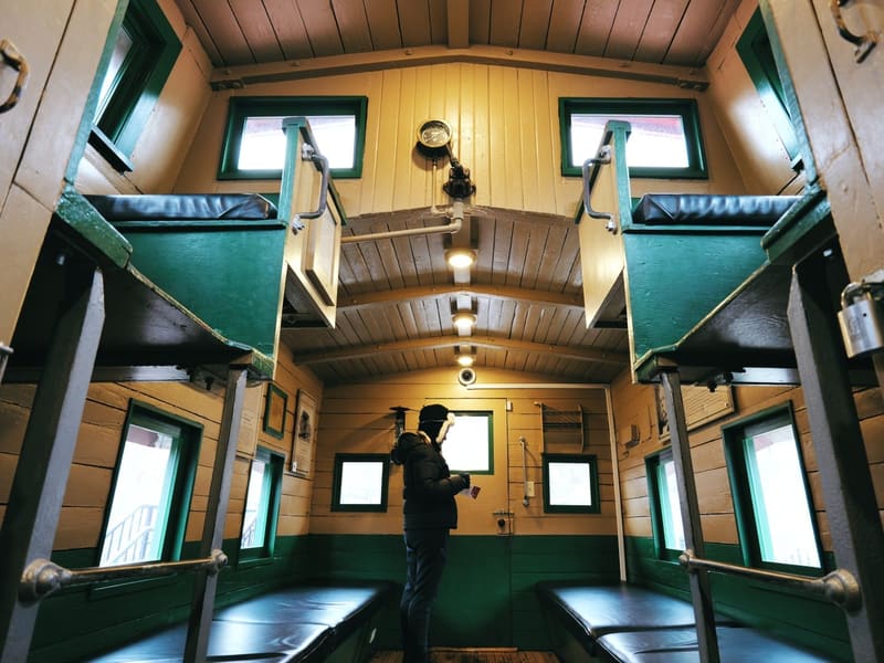 Interior of the B&O caboose, a figure framed beneath the cupola bunks