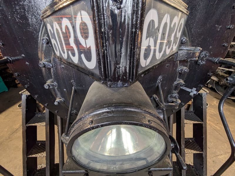 Headlight and number plate '6039' on the front of a steam locomotive
