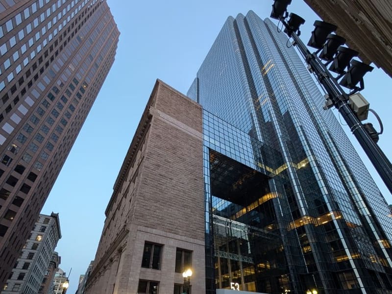 Downtown Boston at dusk, a glass tower beside an older stone building
