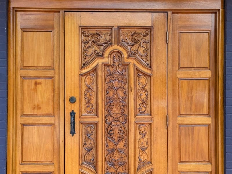 An ornately carved wooden front door marked number 43