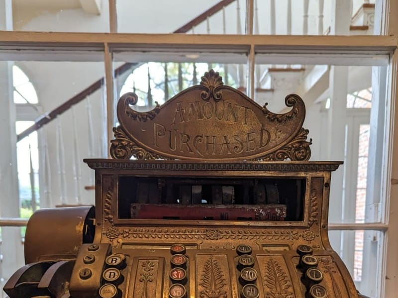 An ornate antique brass National cash register engraved 'Amount Purchased'