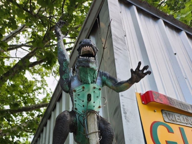 A green folk-art alligator sculpture mounted outside Dr. Bob's Bywater studio