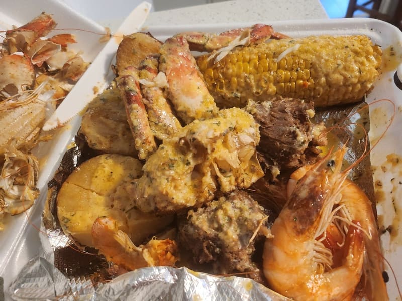 A New Orleans seafood boil tray of crab legs, shrimp, corn, potatoes and sausage