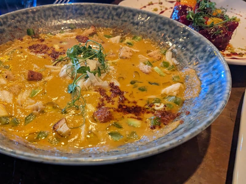 A bowl of creamy New Orleans crab and seafood bisque garnished with herbs