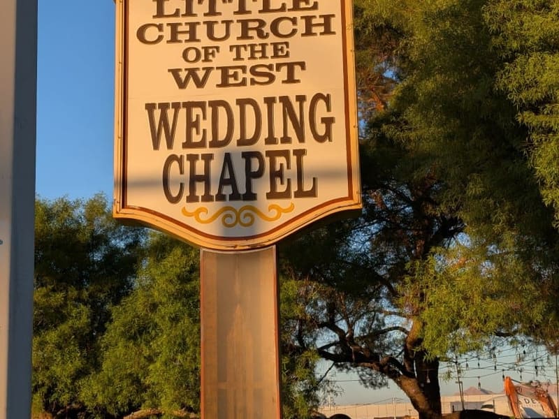 The vintage sign for the Little Church of the West wedding chapel, glowing at golden hour