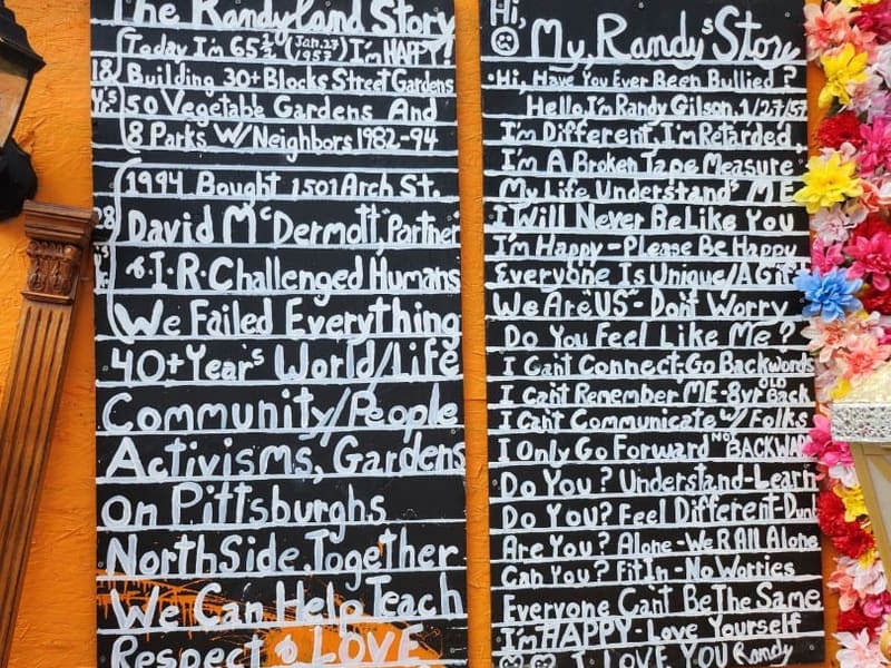 Hand-lettered 'Randyland Story' boards on an orange wall