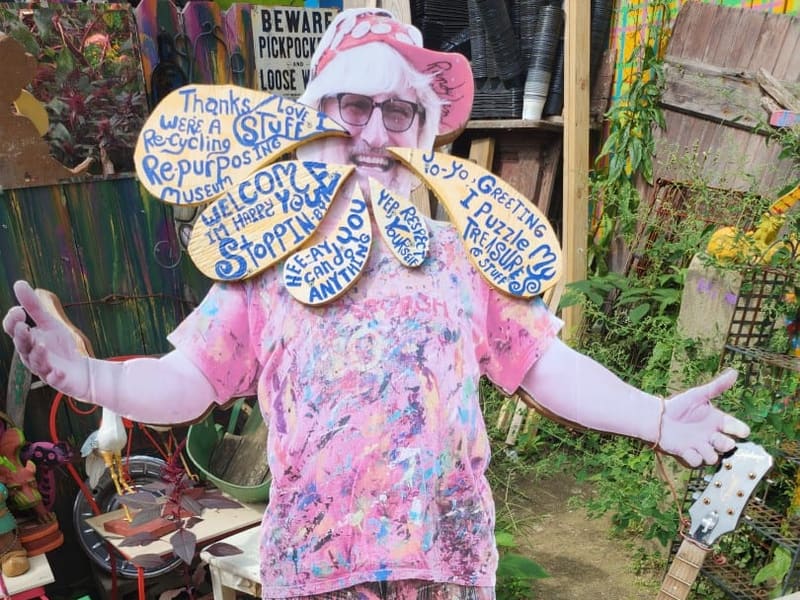 A paint-splattered cutout of Randy welcoming visitors to Randyland
