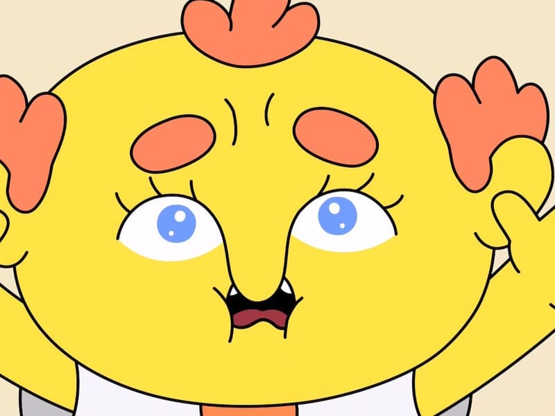 Extreme close-up of the yellow protagonist's face — wide blue eyes, mouth agape, hands raised in cartoonish surprise.