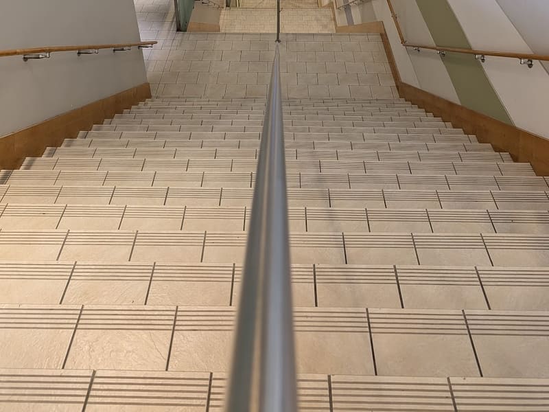 A long staircase with glass railings descending into the Strathmore lobby.
