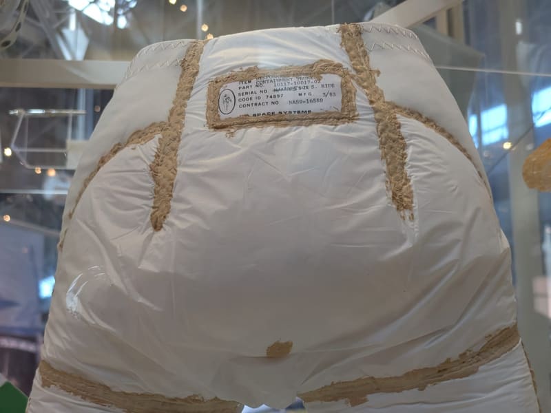 Display of a Shuttle-era 'Disposable Absorption Containment Trunk' with its placard