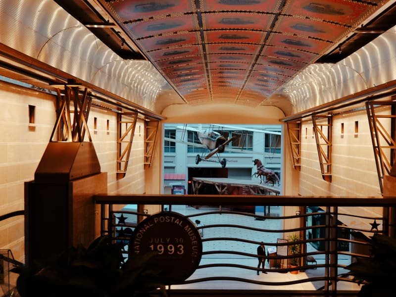 The National Postal Museum's atrium, with historic mail vehicles and a July 1993 opening banner
