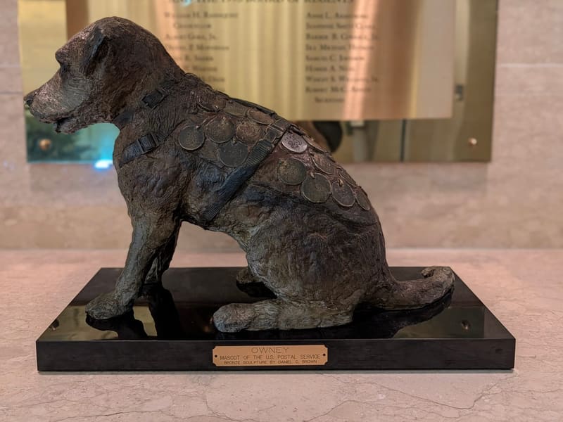 Bronze statue of Owney, the Railway Mail Service's mascot dog, covered in tags