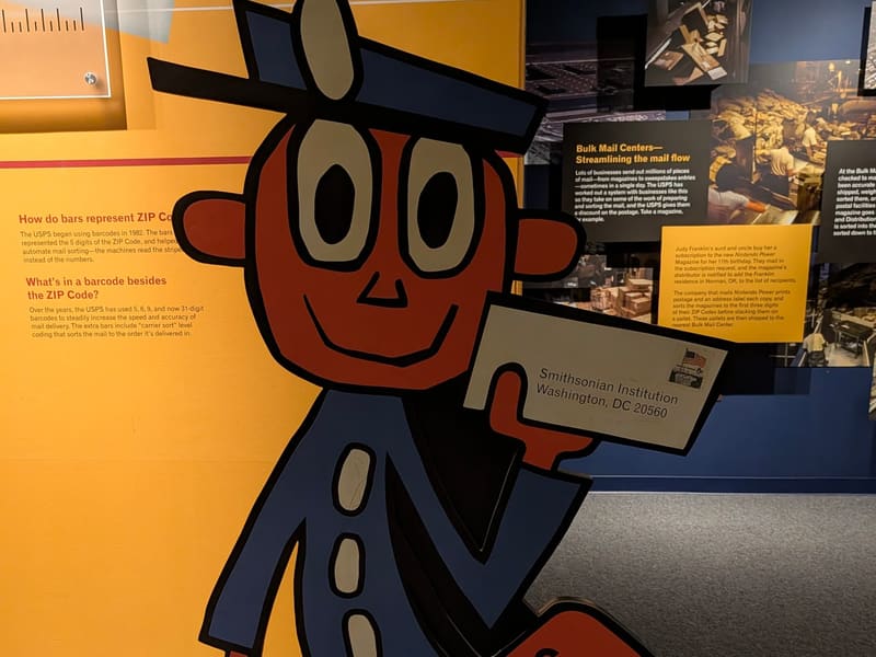 The Mr. ZIP cartoon mascot cutout holding U.S. Mail