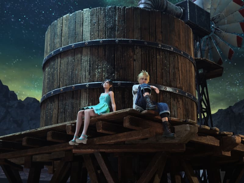 Cloud and Tifa sitting side by side on the wooden platform of a water tower at night, a windmill beside them and an aurora-green starfield over the mountains behind.