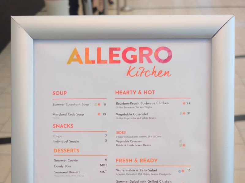 Framed Allegro Kitchen menu board listing soups, snacks, desserts, libations and hot entrees with prices.