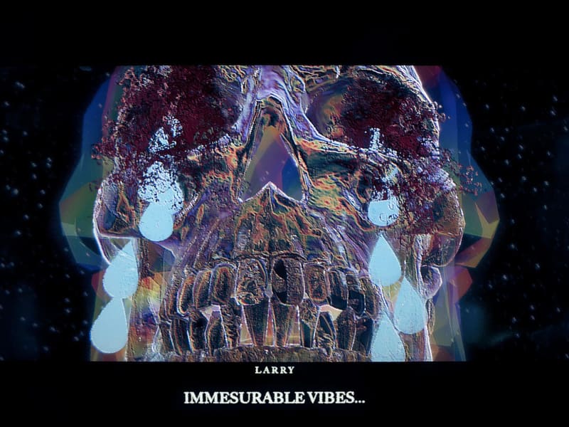 Cutscene close-up of Larry, a giant iridescent glass skull weeping pale teardrops against a starry black void, subtitled “IMMESURABLE VIBES…”